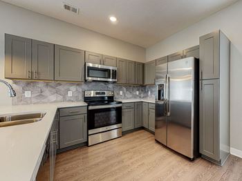 A kitchen with a stainless steel refrigerator and oven.